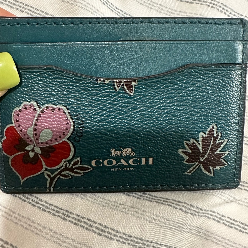 COACH card case in Teal color with floral design.
